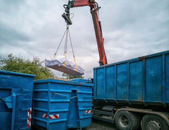 Grue transportant des sacs d'amiante pour les recycler