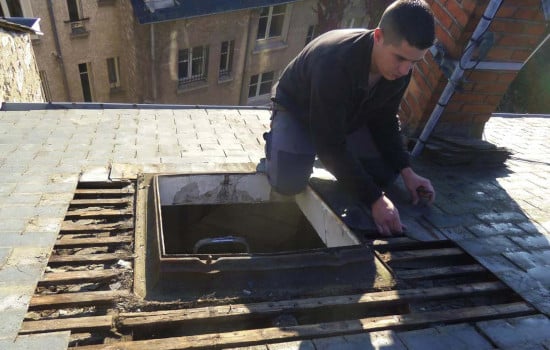 pose d'une fenêtre de toit sur une toiture en ardoise par un artisan couvreur
