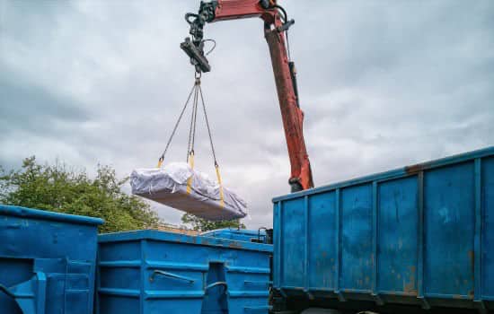 Grue transportant des sacs d'amiante pour les recycler