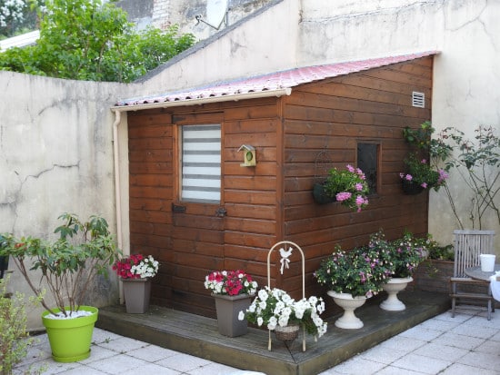 Abri de jardin en bois posé sur une terrasse sur plots