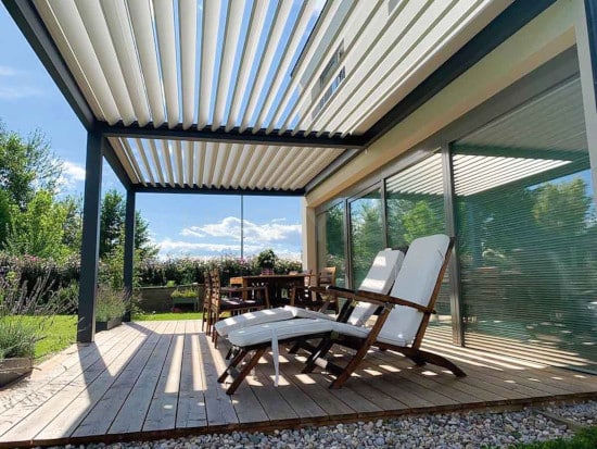Pergola bioclimatique fixée sur une terrasse et dalle gravillonnée
